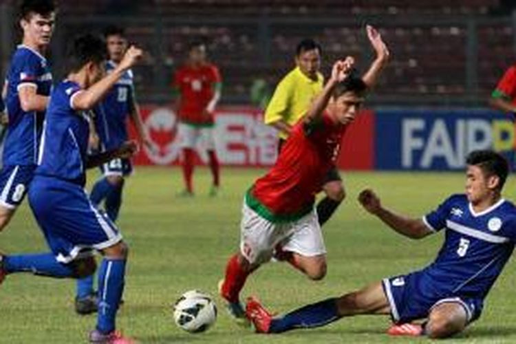Pemain Indonesia, Dinan Yahdian Javier (tengah) berebut bola dengan pemain Filipina, Santos Aguinaldo (kanan) pada pertandingan kualifikasi Piala Asia U-19 di Stadion Utama Gelora Bung Karno, Jakarta, Kamis (10/10/2013). Indonesia unggul 2-0. 