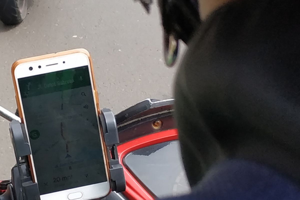 Ojek online menggunakna GPS pada ponsel saat berkendara mengantar dan menjemput penumpang.