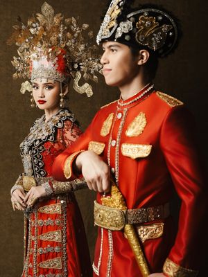 Syifa Hadju dan El Rumi tampil serba merah dalam busana adat Gorontalo saat prewedding. Detail mahkota hingga ornamen emas jadi sorotan.