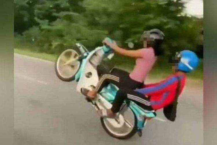 Tangkapan layar dari video dua remaja Malaysia yang melakukan aksi jumping motor pada 10 Mei 2021. Kedua remaja ini kemudian ditangkap polisi, terancam denda maksimal Rp 51,8 juta dan SIM-nya dapat dicabut lima tahun.
