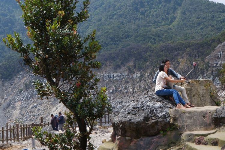 Ilustrasi pengunjung Gunung Tangkuban Parahu sedang berfoto.