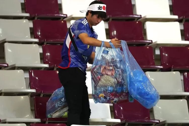 Suporter Jepang bersih-bersih stadion.
