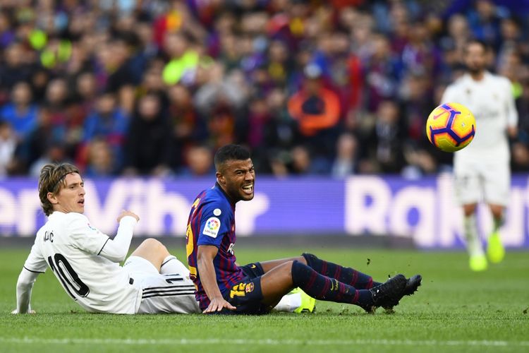 Luka Modric dan Rafinha berebut bola hingga terjatuh pada laga Barcelona vs Real Madrid dalam pertandingan bertajuk El Clasico di Stadion Camp Nou, 28 Oktober 2018. 