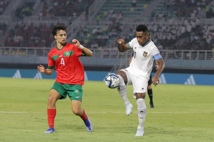 Pemain Timnas Indonesia Iqbal Gwijangge dijaga ketat pemain Maroko Ayoub Chaikhoun saat laga ketiga babak penyisihan Grup A Piala Dunia U17 2023 Indonesia yang berakhir dengan skor 3-1 di Stadion Gelora Bung Tomo Surabaya, Jawa Timur, Kamis (16/11/2023) malam.