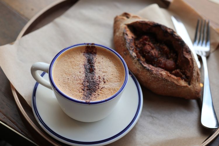 Ilustrasi kopi mocha panas dan sepotong fig bread. 