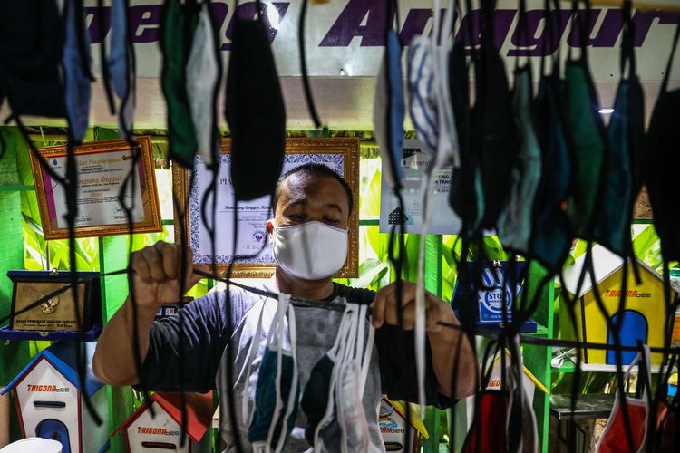 Warga menjemur masker berbahan kain di Kampung Anggur, Kelurahan Uwung Jaya, Kecamatan Cibodas, Kota Tangerang, Banten, Kamis (9/4/2020). Untuk menanggulangi penyebaran virus Covid-19, warga kampung anggrek secara swadaya memproduksi masker dan dibagikan kepada masyarakat sekitar.