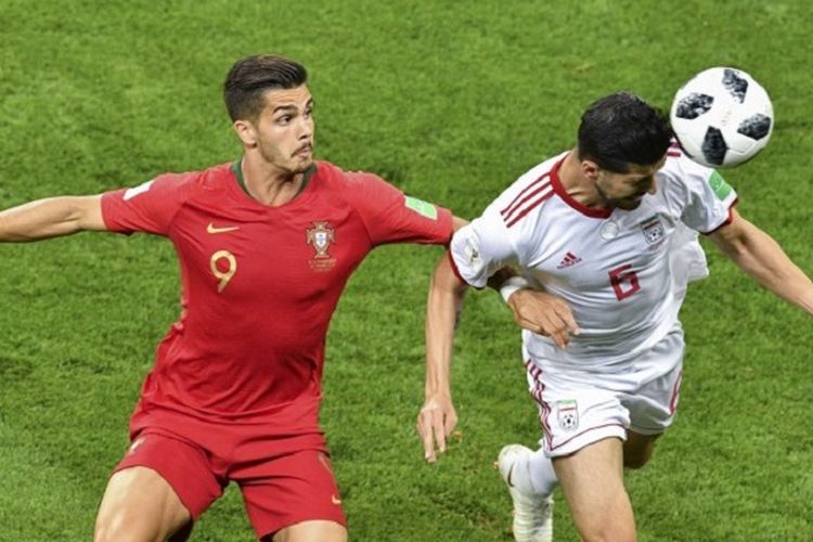 Andre Silva kalah duel udara dengan Saeid Ezatolahi pada pertandingan Iran vs Portugal di Saransk, 25 Juni 2018. 