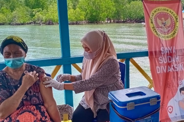 Rumina, warga Desa Panambea Barat, Kabupaten Konawe Selatan, Sultra menerima vaksin dosis 1 di kegiatan vaksinasi BIN Sultra. (KIKI ANDI PATI/ kompas.com)