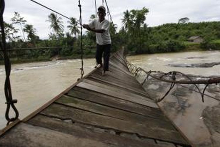 Ilustrasi: jembatan gantung di Desa Sukajaya, Kecamatan Sajira, Kabupaten Lebak, Banten, rusak hingga tak bisa dipergunakan warga, Kamis (9/1/2014). Kawat besi jembatan yang pernah diperbaiki tahun 2011 putus dan mengakibatkan aktivitas warga terutama anak-anak sekolah dan petani terhambat. Saat air sungai Ciberang surut, warga berjalan kaki menyeberangi sungai, namun saat debit sungai meningkat mereka harus memutar jalan yang lebih jauh. KOMPAS/LUCKY PRANSISKA 