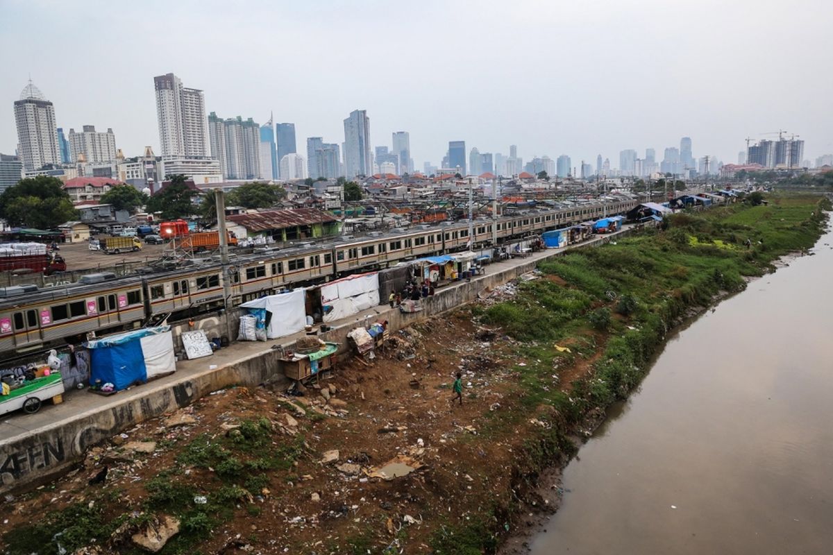 Kereta listrik (KRL) melintas di samping deretan bangunan liar di sepanjang tepi Sungai Ciliwung, Jalan Tenaga Listrik, Tanah Abang, Jakarta Pusat, Sabtu (30/9/2017). Gubuk liar kembali berdiri di sepanjang Sungai Ciliwung akibat kurangnya pengawasan dari Pemprov DKI Jakarta.