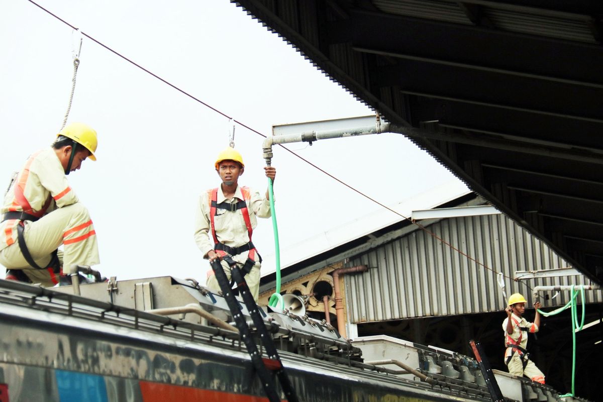 Terlihat petugas KAI sedang melakukan menguras air di tangki toilet dan mengisi ulang di lokasi stabling cuci kereta. 