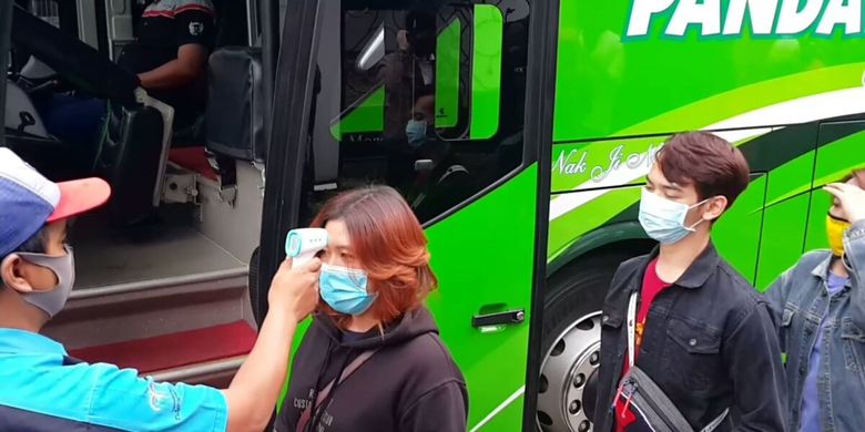 Wisatawan dicek suhu tubuhnya sebelum memasuki Bus Pandawa87 yang membawanya keliling kota, Sabtu (11/7/2020)