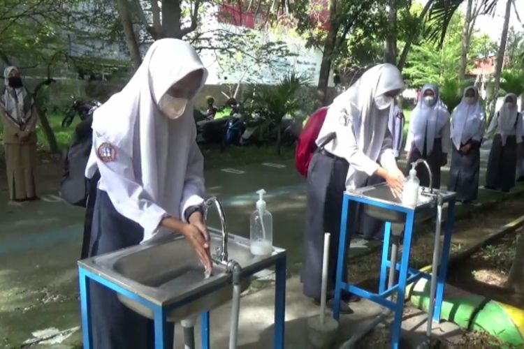 Sekolah Tatap Muka Disambut Antusias, Siswa Antri Cuci Tangan dan Periksa Suhu Tubuh Puluhan Meter di Pintu Gerbang