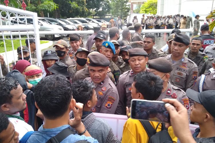 Puluhan mahasiswa menggelar aksi demo menolak kenaikan harga BBM di kantor gubernur Maluku, Senin (12/9/2022). Massa aksi sepat terlibat aksi saling dorong dengan polisi di depan pintu pagar kantor tersebut