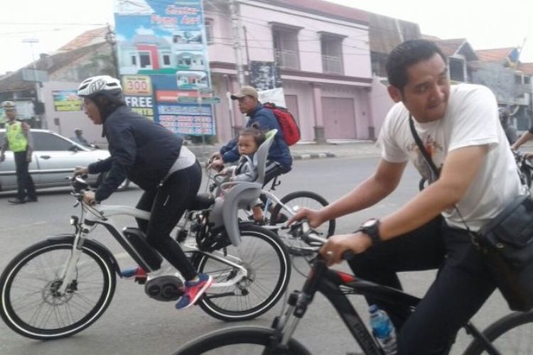 Menteri Susi (kiri) bersepeda sambil membonceng cucunya berkeliling Kota Tegal, Jumat (2/2/2018) pagi.