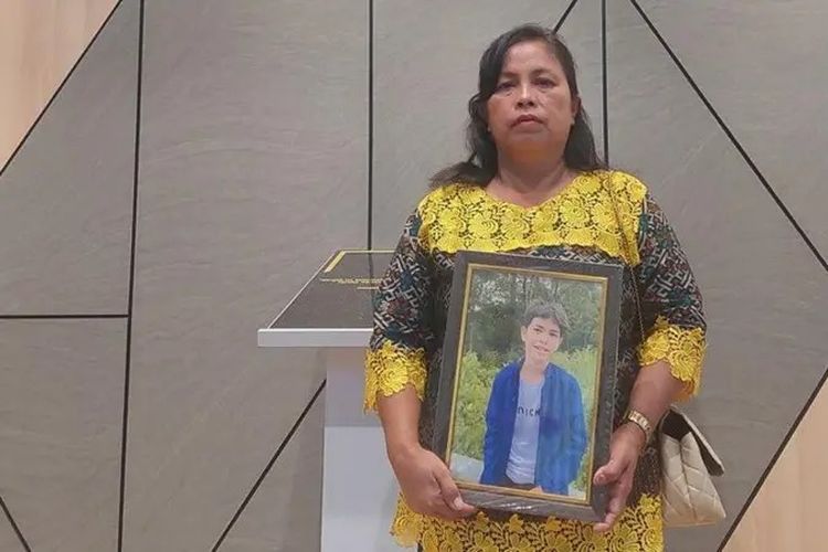 Lenny Damanik memegang foto putra bungsunya Mikael Sitanggang.