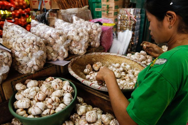 Pedagang mensortir bawang putih di Pasar Induk Kramat Jati, Jakarta Timur, Senin (10/02/2020). 