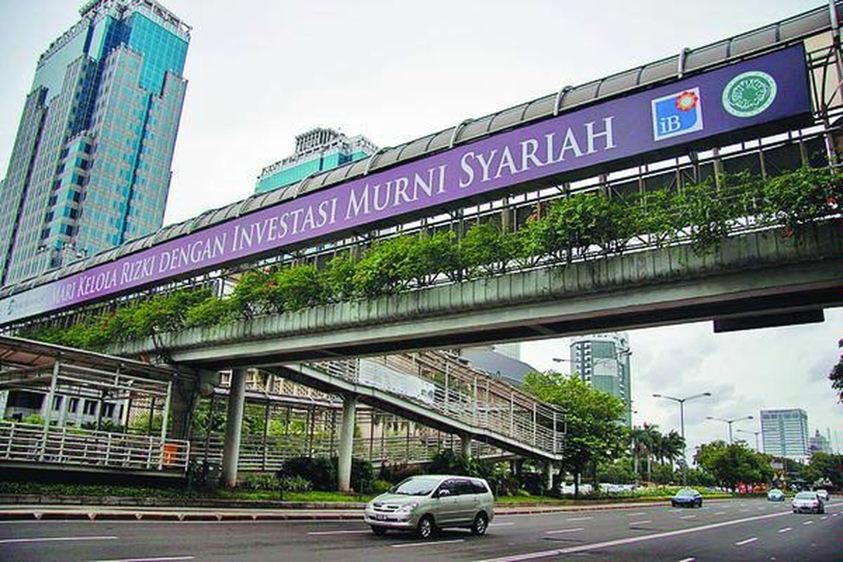 Sebuah papan reklame Bank Muamalat di jembatan penyeberangan di Jalan MH Thamrin, Jakarta Pusat, Selasa (18/11). Kantor bank yang melayani transaksi perbankan syariah harus memasang logo Islamic Banking. Pemasangan logo ini diwajibkan oleh Bank Indonesia untuk mengoptimalkan layanan perbankan syariah kepada masyarakat umum.  