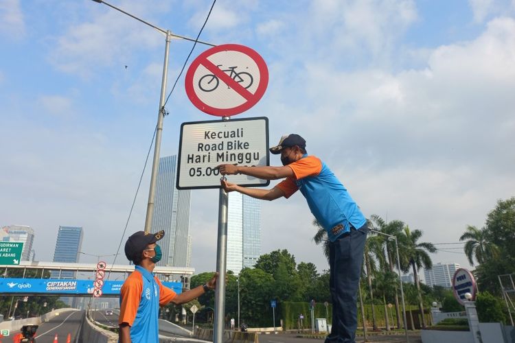 Petugas Dinas Perhubungan DKI Jakarta mencopot rambu larangan sepeda selain road bike melintas di JLNT Kampung Melayu-Tanah Abang, Minggu (13/6/2021).