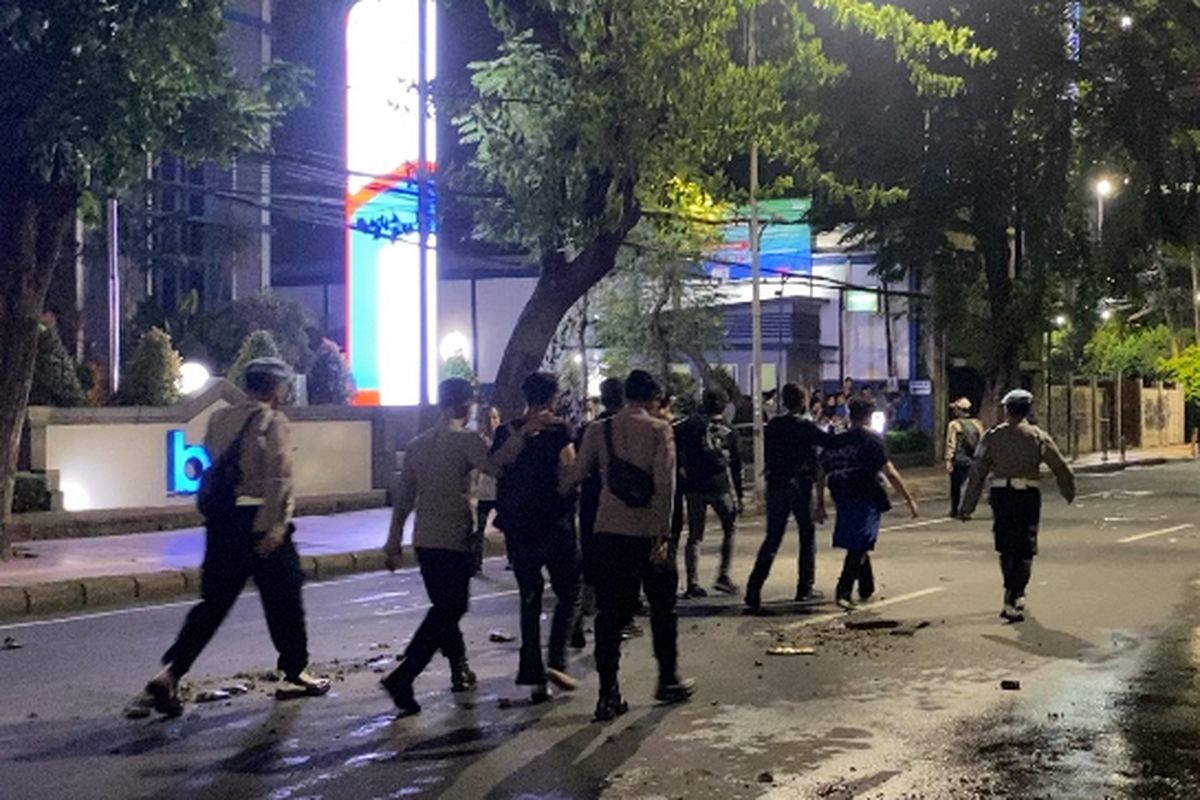 Polisi saat menangkap demonstran di Jalan Pemuda, Surabaya, Senin (24/3/2025).