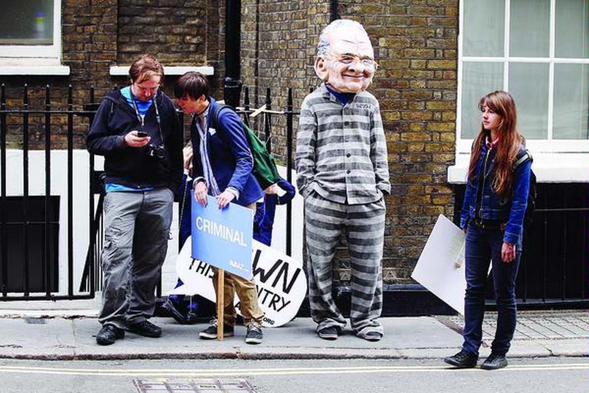 Pemrotes  menggunakan topeng berwajahkan Rupert Murdoch di luar apartemen pemimpin News Corp itu, Rabu (13/7) di London. Tiga partai politik Inggris turut mendukung mosi yang meminta News Corp membatalkan akuisisi televisi BSkyB  sementara penyelidikan soal penyadapan telepon di News of the World berlangsung.