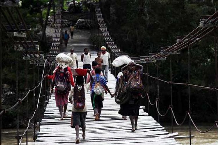 Warga menyeberangi jembatan gantung di Distrik Bolakme, Jayawijaya, Papua, Jumat (6/12/2013). 