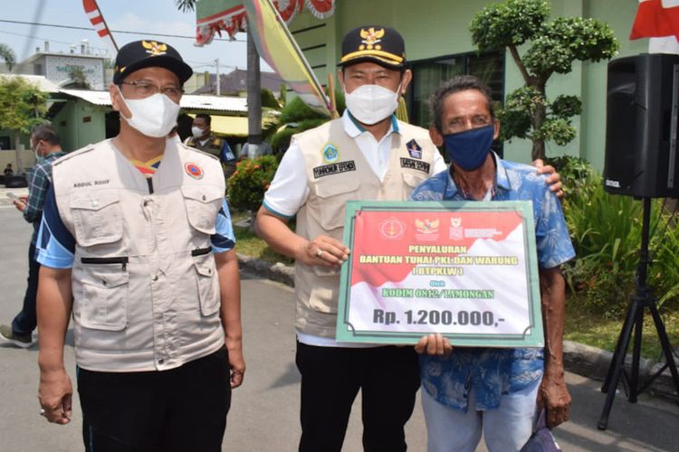 Bupati Lamongan Yuhronur Efendi (tengah) dan Wakil Bupati Abdul Rouf (kiri) saat foto bersama salah seorang penerima BTPKLW, Jumat (15/10/2021).