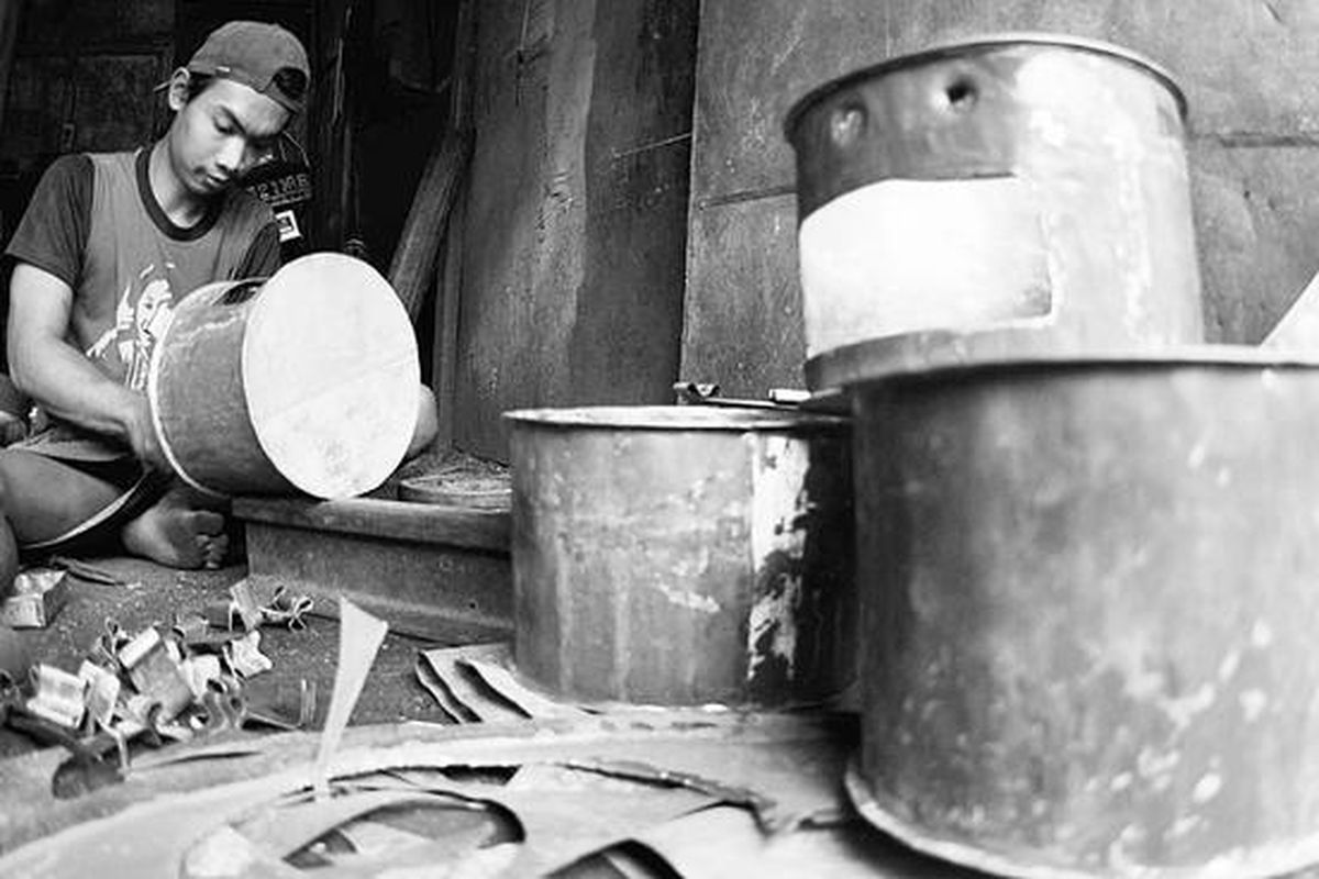 Heru menyelesaikan pembuatan tungku memasak dari bahan drum bekas di Pasar Kabangan, Kota Solo, Jawa Tengah, Senin (26/7). Sejak konversi bahan bakar minyak ke elpiji, Heru yang dulu memproduksi kompor minyak kini beralih membuat tungku berbahan bakar arang kayu. Tiap hari ia mampu membuat 10 tungku yang dijual dengan harga Rp 15.000 per unit.