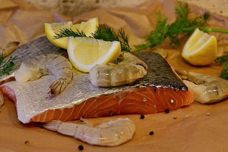 Ilustrasi ikan salmon dan udang yang dibumbui irisan jeruk nipis dan rosemary. 