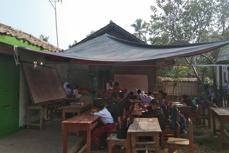 Puluhan murid SDN Malangsari II belajar di halaman rumah warga dan beratapkan terpal labtaran gedung sekolah tengah direhab, Rabu (16/10/2019).