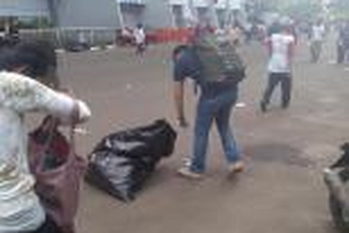 Salah seorang relawan Jokowi yang memungut sampah saat berlangsungnya acara konser Salam 2 Jari, di Stadion Gelora Bung Karno, Sabtu (5/7/2014)