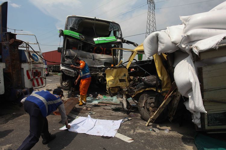 Petugas mengevakuasi bus pariwisata dan truk yang terlibat kecelakaan di Tol Dupak - Tanjung Perak Surabaya, Jawa Timur, Sabtu (5/3/2022). Kecelakaan antara bus pariwisata bernopol D 7610 AT yang memuat rombongan peziarah dengan truk 'Colt Diesel' nomor polisi W 9948 Z itu diduga disebabkan salah satu penumpang bus merebut kendali kemudi dari sopir bus dan menabrak truk 'Colt Diesel' dari arah berlawanan. Dalam kecelakaan itu sopir truk dan kernetnya meninggal dunia di lokasi kecelakaan.