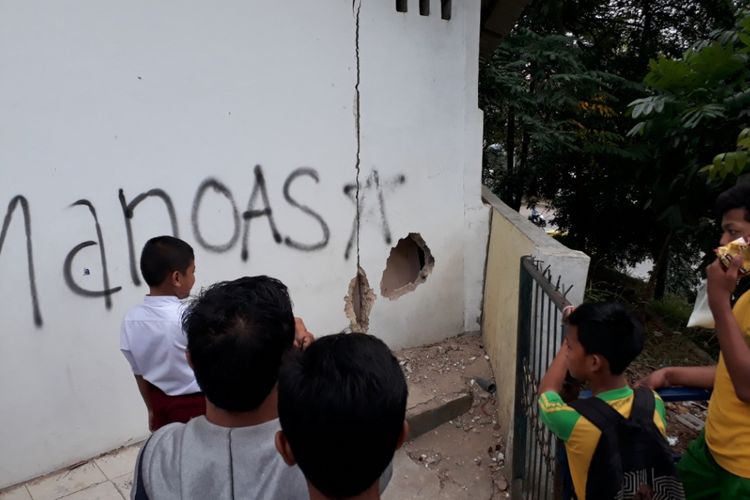 Salah seorang siswa SDN 002 Sei Panas Batam, Kepulauan Riau, menunjukkan dinding sekolah yang dijebol sebagai pintu masuk pelaku menguras barang berharga milik sekolah.