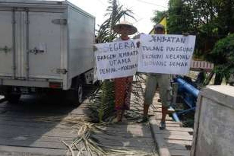 Dua aktivis Aliansi Pemuda Pantura saat menggelar protes diatas jembatan darurat di Bonang , Demak, Minggu (1/5/2015)