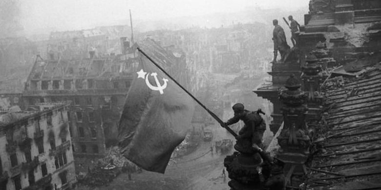 Tentara Soviet mengibarkan bendera di atas gedung parlemen Jerman atau Reichstag di Berlin pada 1945.
