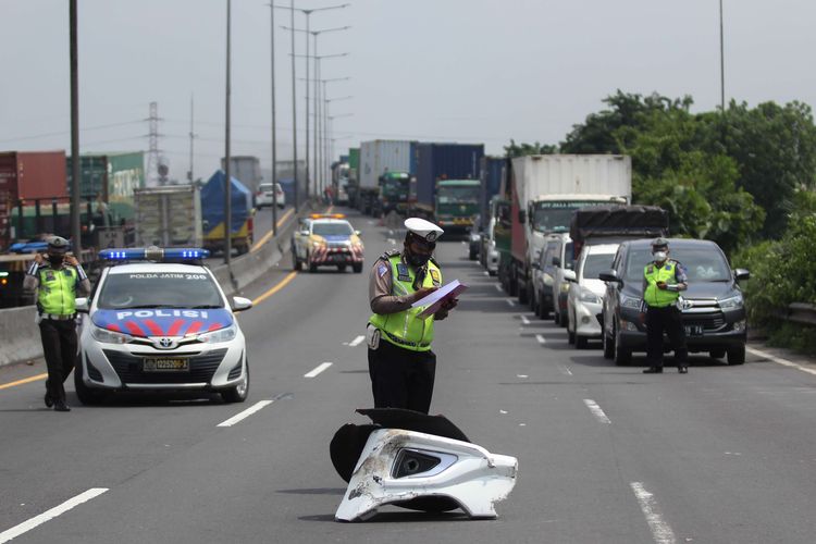 Polisi melakukan pemeriksaan di lokasi kecelakan bus pariwisata dengan truk di Tol Dupak - Tanjung Perak Surabaya, Jawa Timur, Sabtu (5/3/2022). Kecelakaan antara bus pariwisata bernopol D 7610 AT yang memuat rombongan peziarah dengan truk 'Colt Diesel' nomor polisi W 9948 Z itu diduga disebabkan salah satu penumpang bus merebut kendali kemudi dari sopir bus dan menabrak truk 'Colt Diesel' dari arah berlawanan. Dalam kecelakaan itu sopir truk dan kernetnya meninggal dunia di lokasi kecelakaan.