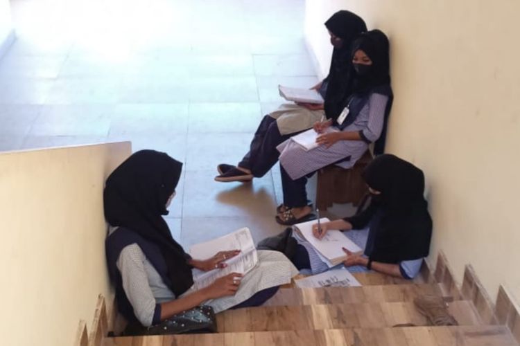 Foto siswi yang duduk di tangga kampus yang viral di media sosial. Mereka dilaporkan dilarang masuk ke kelas karena memakai jilbab.