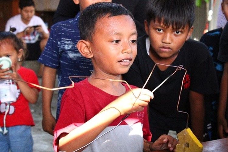 Salah satu anak mencoba kawat buzzer hasil inovasi mahasiswa KKN Universitas Negeri Yogyakarta (UNY).