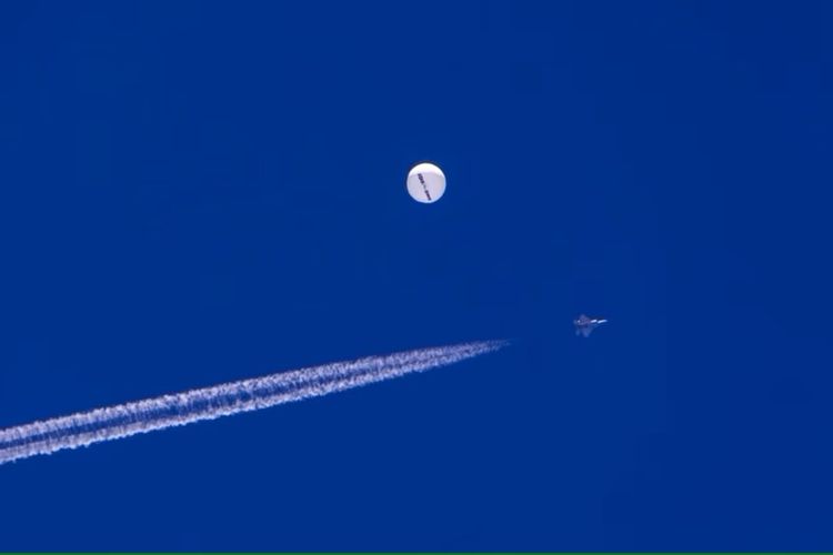 Sebuiah jet tempur terbang melintasi balon yang berada di atas Samudra Atlantik, di lepas pantai South Carolina, pada 4 Februari 2023.