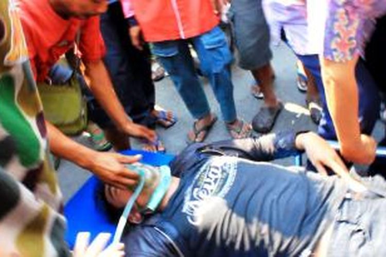 Seorang karyawan terjatuh pingsan setelah menerobos kepulan asap tebal yang berusaha membantu memadamkan api yang membakar delapan rumah toko di kota Cirebon, Kamis (18/9/2014). 