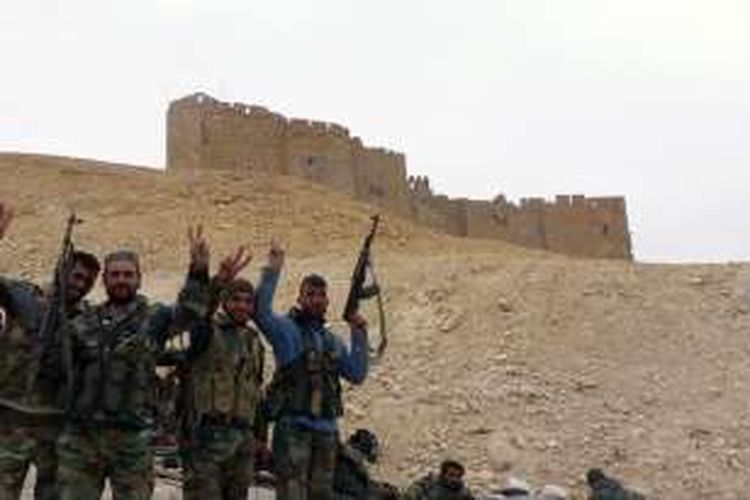 Sekelompok prajurit Suriah merayakan kesuksesan mereka merebut kembali kota Palmyra dari tangan ISIS, Minggu (27/3/2016).