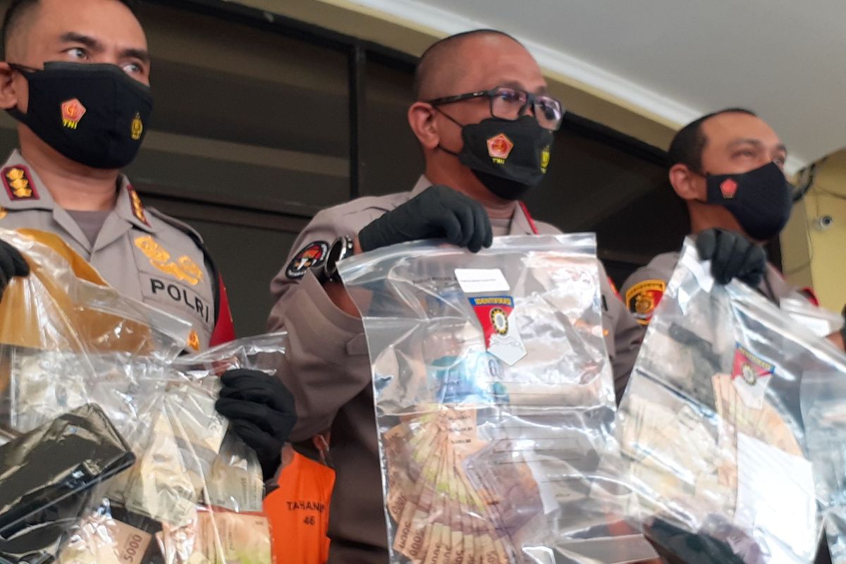 Kepala Bidang Hubungan Masyarakat Polda Metro Jaya, Komisaris Besar Polisi Yusri Yunus, memegang barang bukti penangkapan tersangka pungutan liar (pungli) di Polrestabes Jakarta Utara, Jumat (11/6/2021).