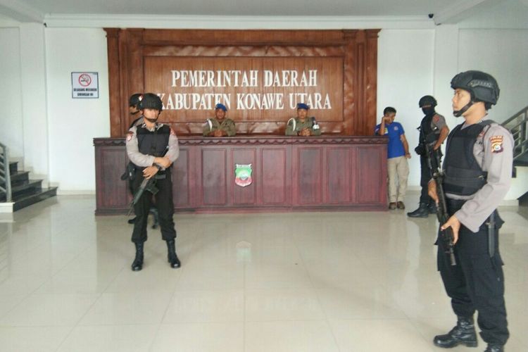 Petugas polisi bersenjata lengkap mengawal penggeledahan tim KPK di kantor Bupati Konawe Utara.