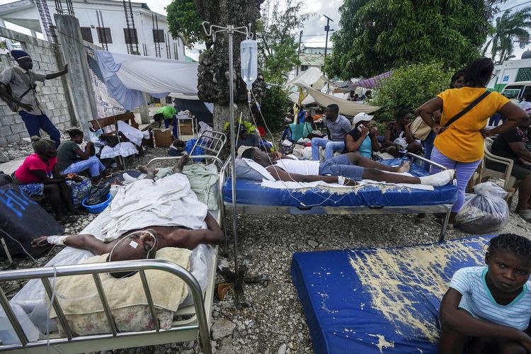 Orang yang terluka berbaring di tempat tidur di luar rumah sakit Immaculée Conception di Les Cayes, Haiti, Senin, 16 Agustus 2021, dua hari setelah gempa berkekuatan 7,2 melanda bagian barat daya negara itu. 