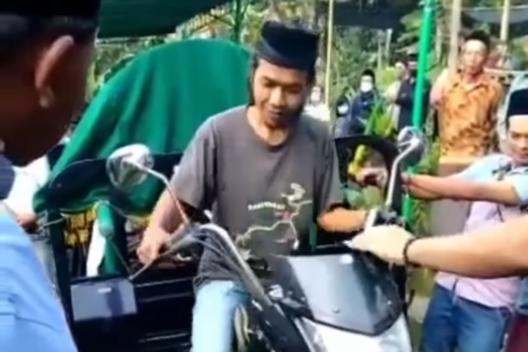 Foto tangkapan layar pengangkutan jenazah menggunakan sepeda motor roda tiga.