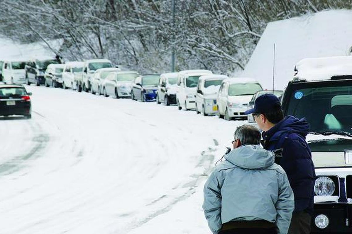 Kendaraan mengantre sepanjang lebih dari 5 kilometer untuk mengisi bahan bakar minyak dan gas di Kesennuma, Prefektur Miyagi, Jumat (18/3), di tengah suhu yang mencapai minus 4 derajat celsius. Daerah ini paling parah terkena dampak gempa dan tsunami. Hingga sepekan warga di daerah ini masih kekurangan bahan makanan dan bahan bakar.