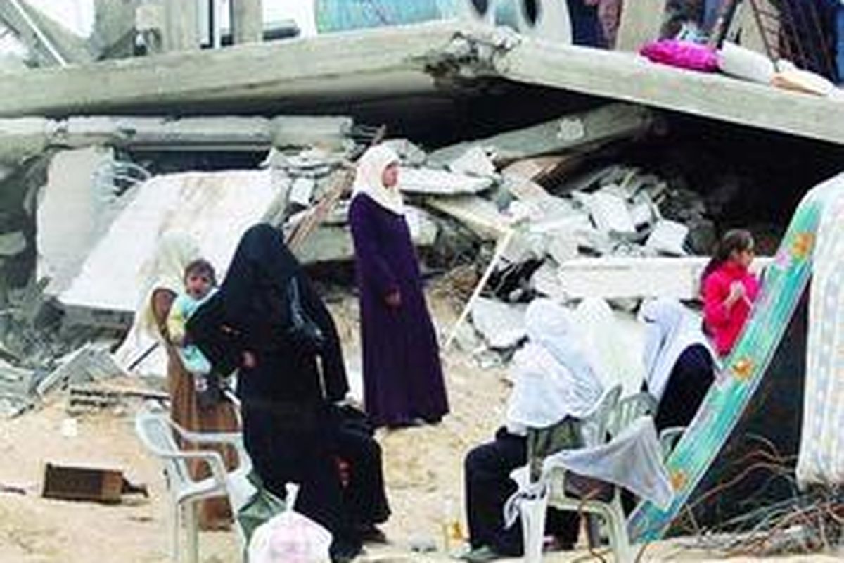 Beberapa perempuan Palestina di Bukit Jabaliya, Jabaliya Timur, Jalur Gaza, Jumat (23/1), berkumpul di depan reruntuhan rumah karena digempur pesawat tempur Israel. Mereka dan semua anggota keluarganya harus tidur di pengungsian sampai rumah mereka dibangun lagi.