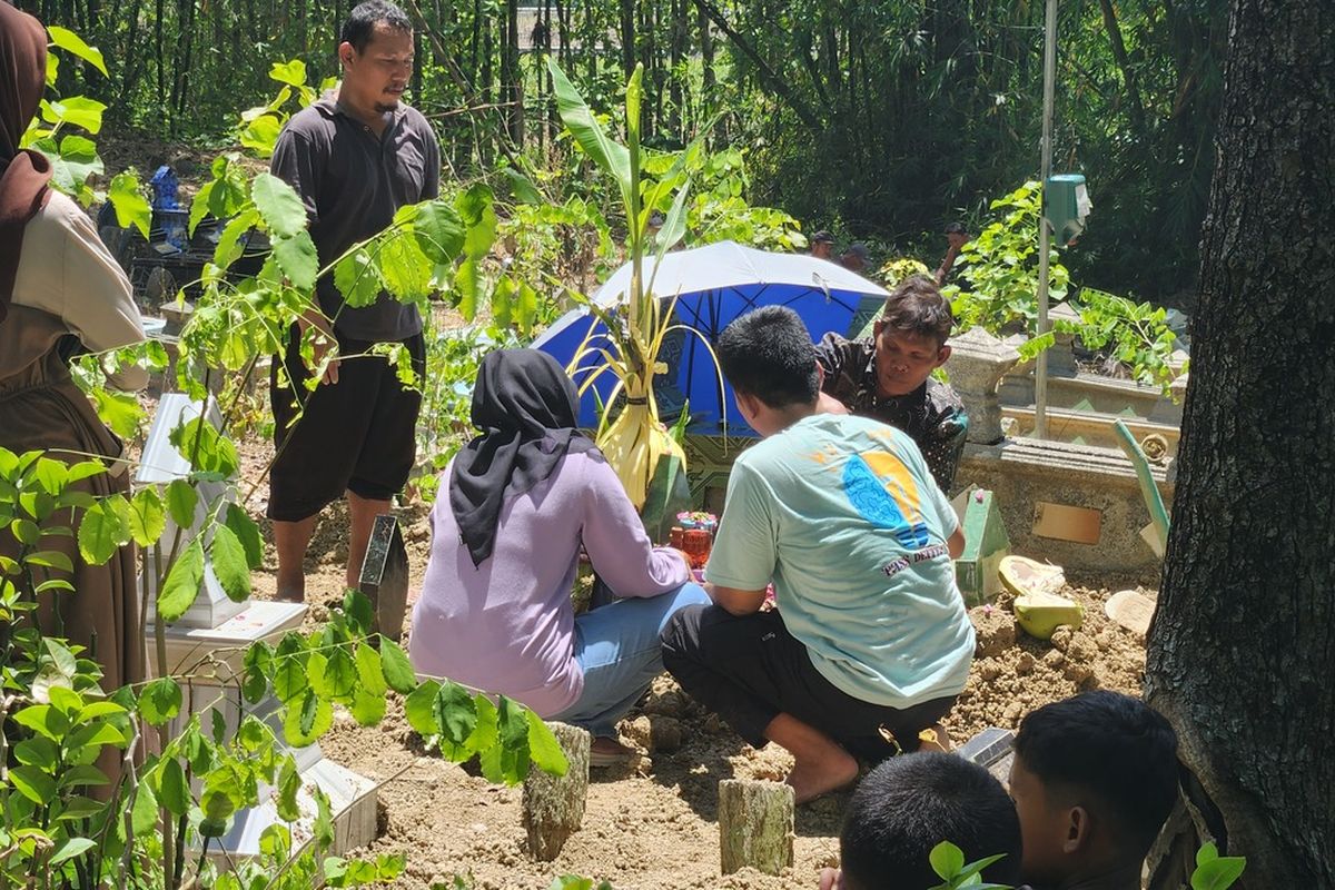 Orangtua Angga, Sawendra (38) dan Ike Purwitasari (34), mengantar jenazah anak sulungnya ke peristirahatan terakhir di Pemakaman Umum, Dusun Muneng, Desa Ledokdawan, Kecamatan Geyer, Kabupaten Grobogan, Jawa Tengah, Minggu (12/10/2025) pagi.