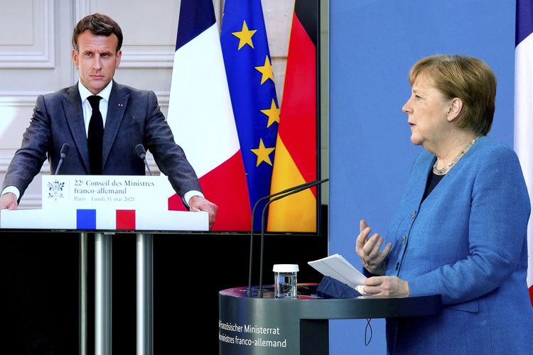Presiden Perancis Emmanuel Macron (kiri) terlihat di layar video dalam konferensi pers gabungan dengan Kanselir Jerman Angela Merkel (kanan), dalam rangkaian acara virtual Rapat Pleno Dewan Menteri Perancis-Jerman di Berlin, Senin (31/5/2021).