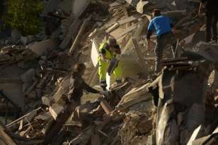 Warga dan petugas penyelamat bahu-membahu mencari korban yang mungkin terjebak di balik reruntuhan bangunan setelah gempa 6,2 magnitudo mengguncang Kota Amatrice, bagian tengah Italia, pada Rabu (24/8/2016).